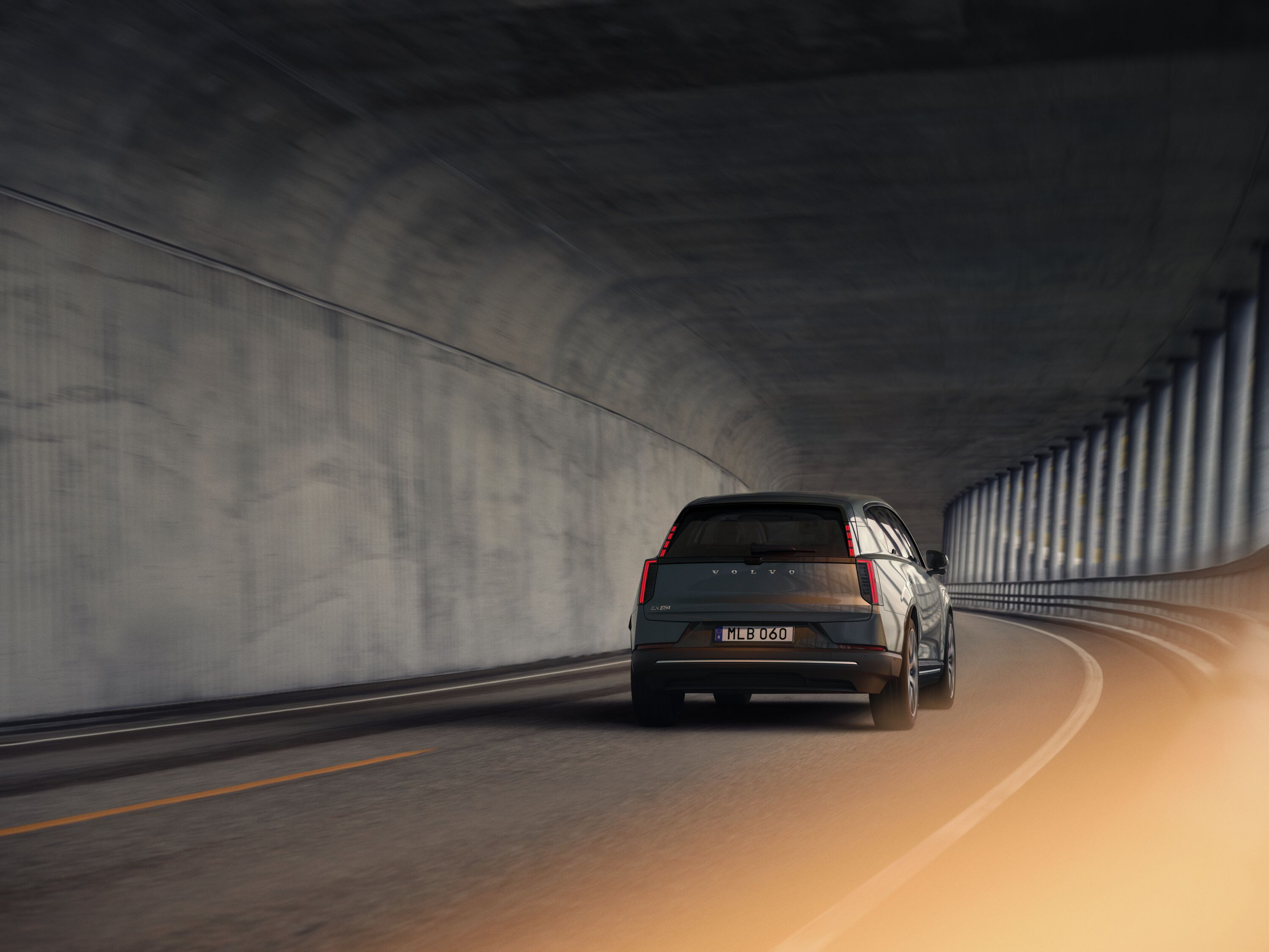 Volvo EX60 som kör på väg sedd bakifrån