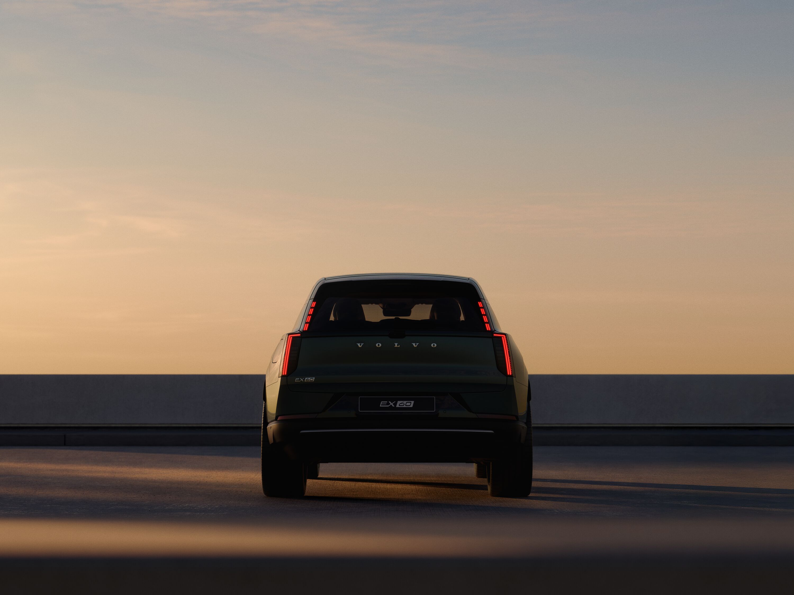 Volvo EX60 parkerad vid hav sedd bakifrån